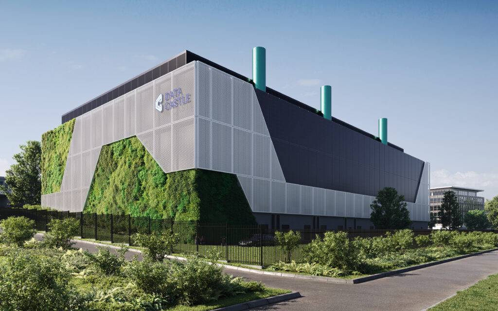 Modern data center building with angular architecture surrounded by greenery under a clear blue sky.
